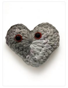 Crocheted heart amigurumi in shades of grey